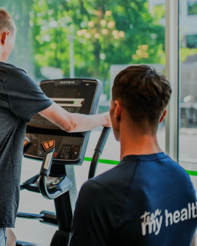 trainer-eddy-begeleidt-sporter-op-de-crosstrainer