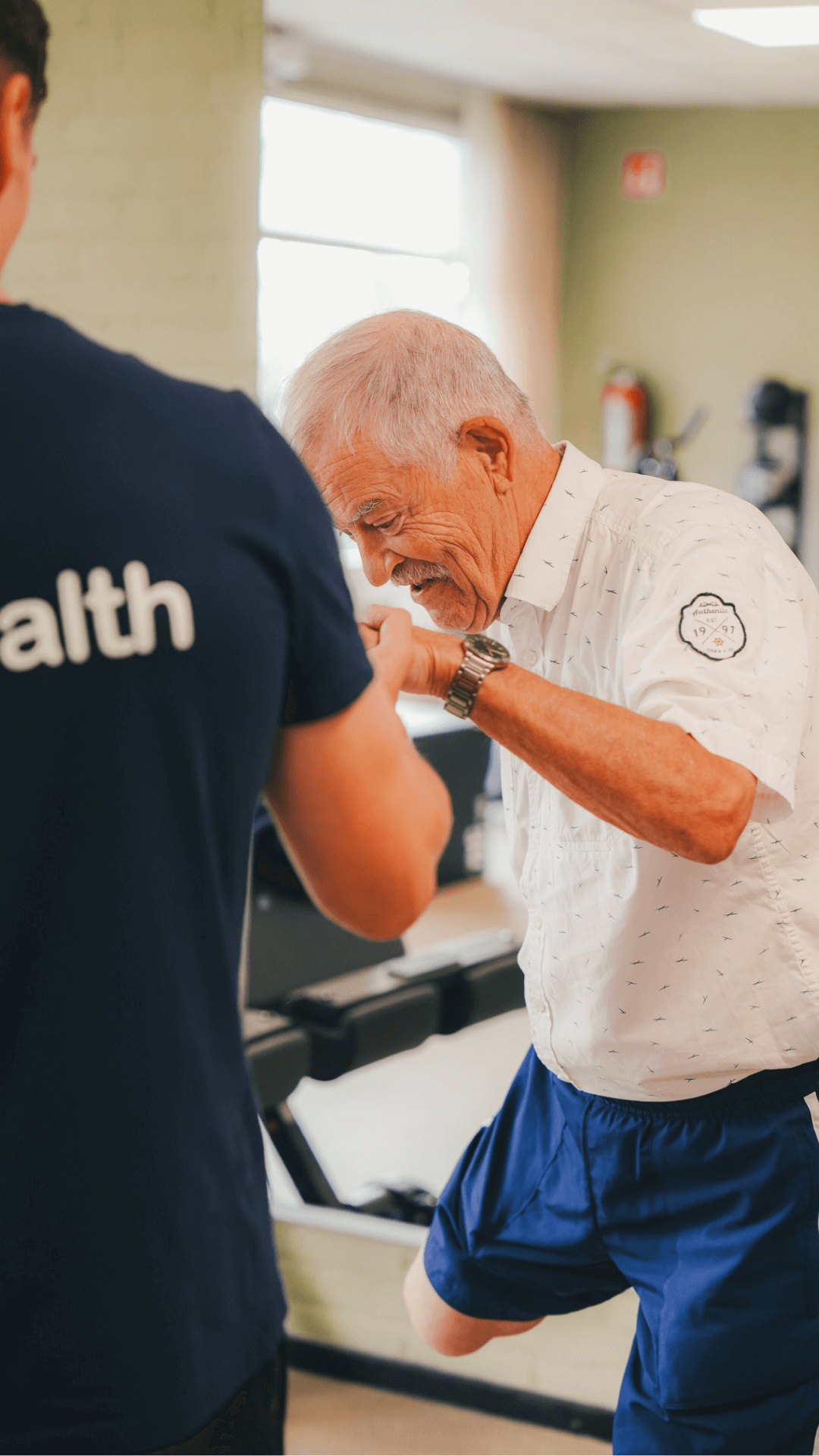 Trainer helpt een 60-plusser bij een oefening bij MyHealth