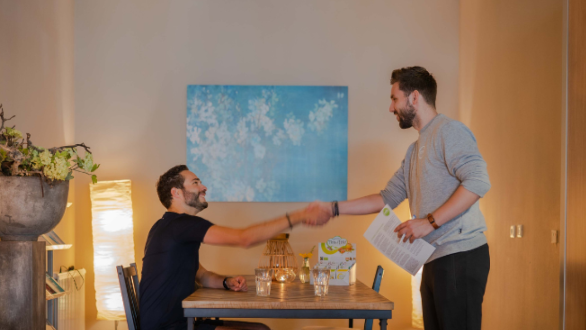 Coach geeft een deelnemer een hand bij een kennismakingsgesprek